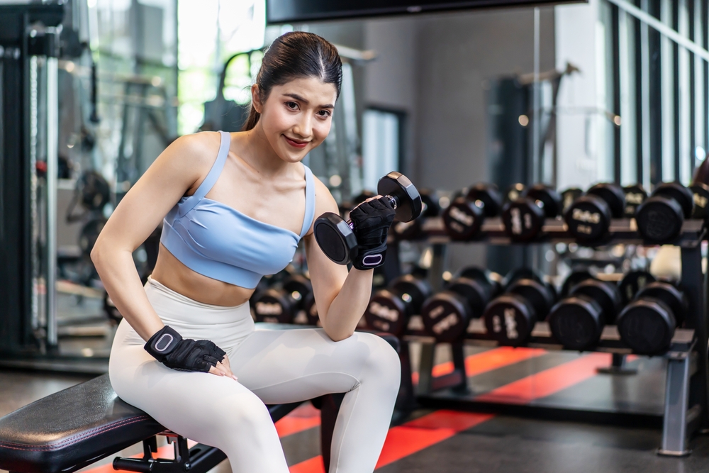 Weights training, Young asian woman lifting weights with equipment in the background, Sportswear girl workout with strong beautiful fit body shape, Asia lifestyle with copy space