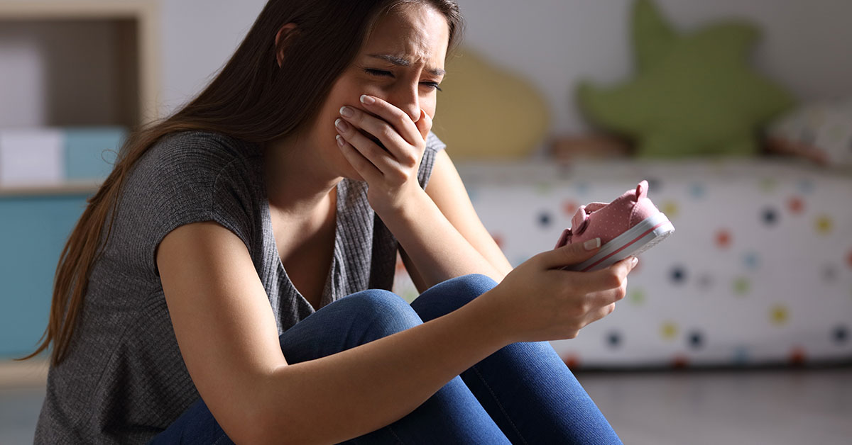 woman crying while looking at her phone