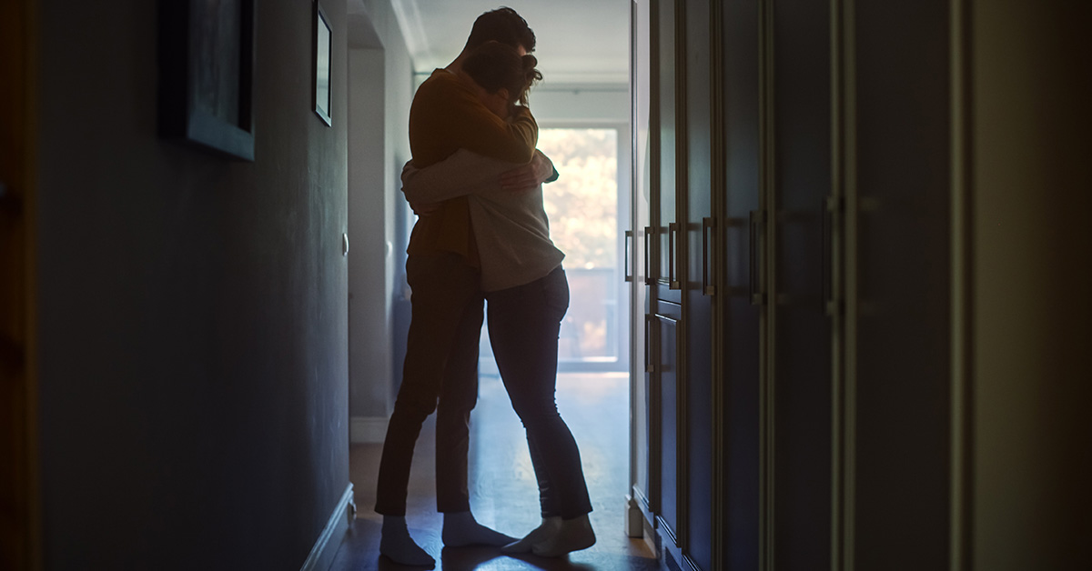 couple embracing in backlit hallway