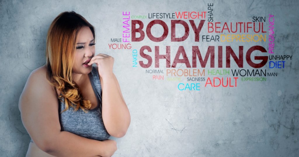 Image of Caucasian obese woman looks fearfully while standing with text of body shaming in the studio