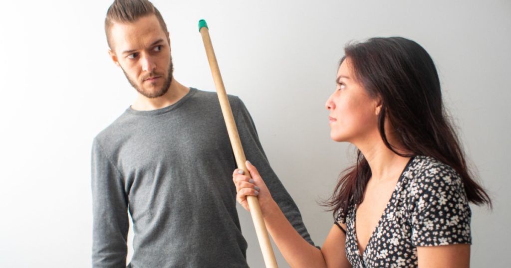 Latin Hispanic Woman Threatens Caucasian Man with Broomstick
