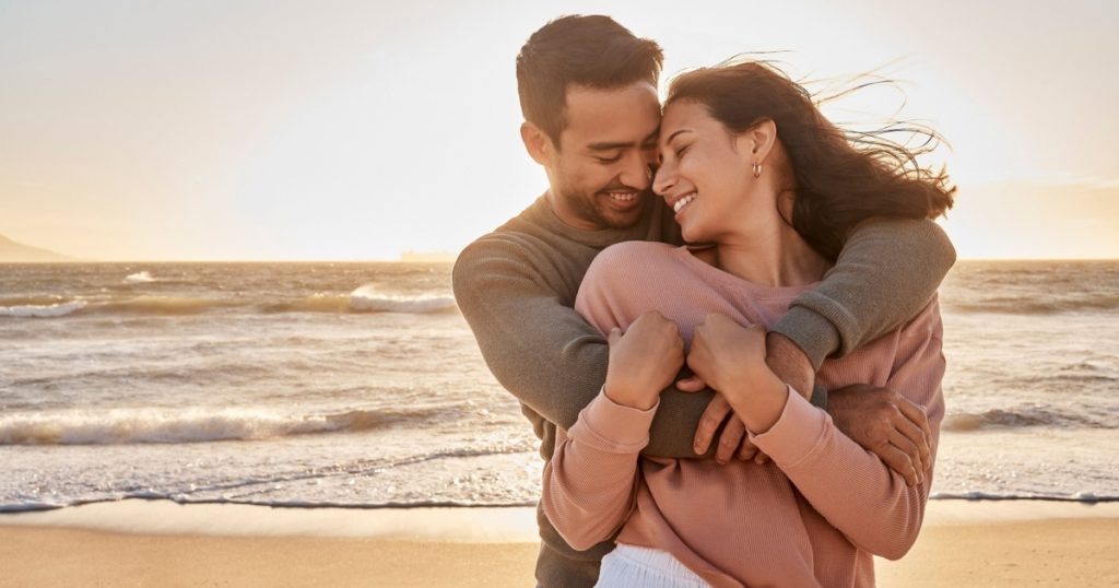Young diverse biracial couple having fun at the beach together. Young diverse biracial couple having fun at the beach together.