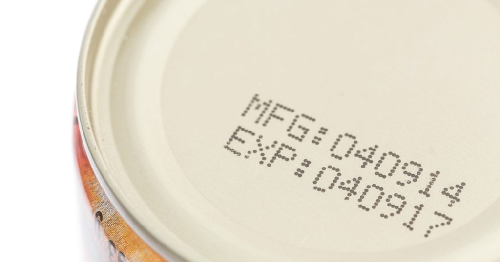Macro expiration date on canned food isolated on white background