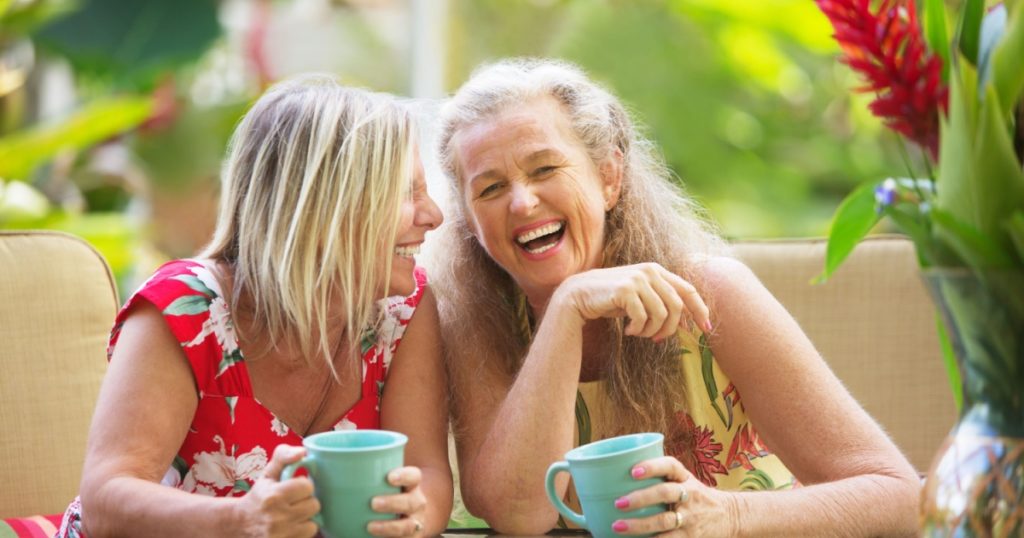 Pair of cute middle aged female friends laughing
