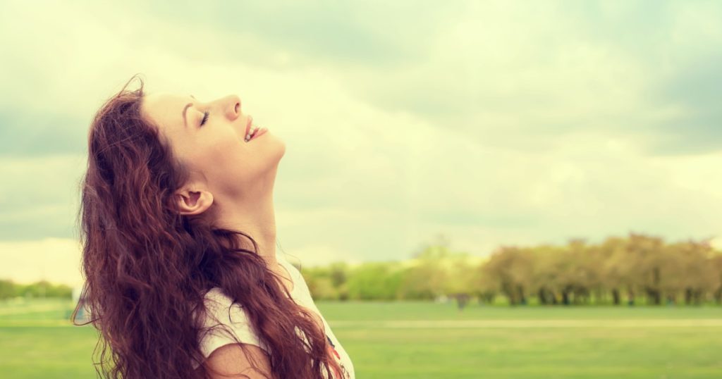 Side profile woman smiling looking up to blue sky celebrating enjoying freedom. Positive emotion face expression life perception success, peace of mind concept. Free happy girl