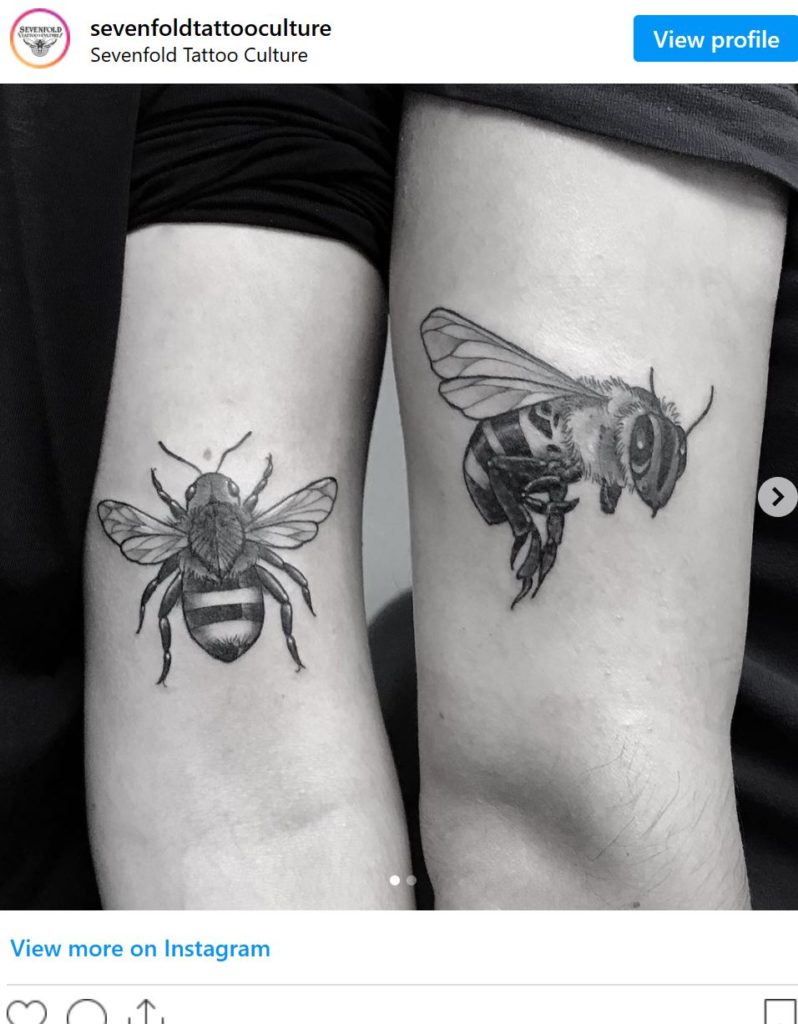 Arms with bee tattoos.  