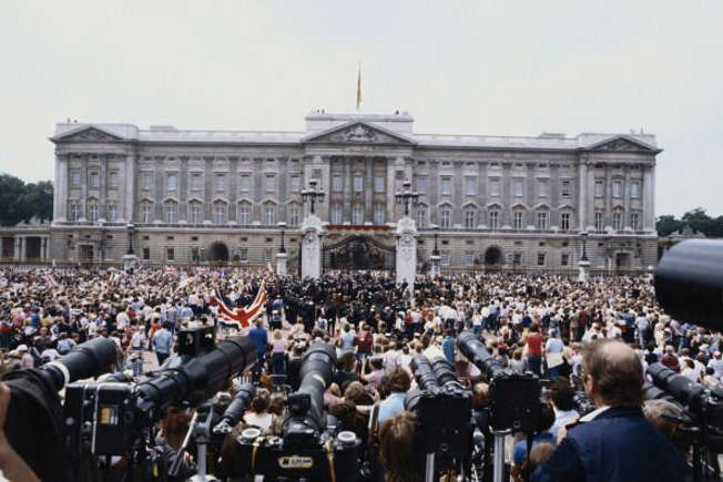 The crowd awaiting outside Buckingham Palace, looking at the balcony.