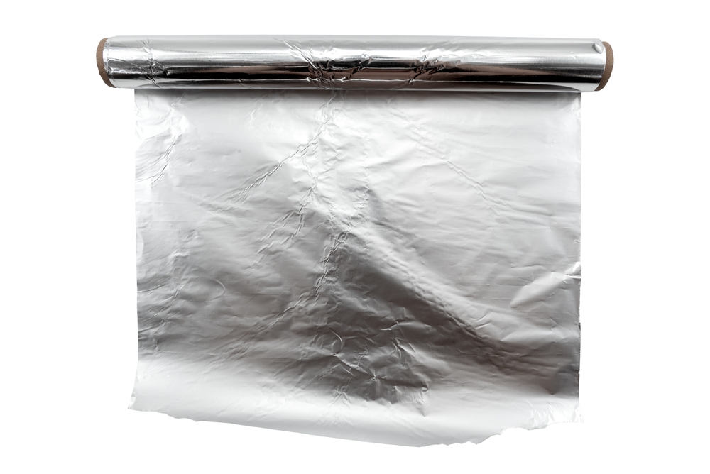 Roll of foil on a white background. Unrolled aluminum foil insulation