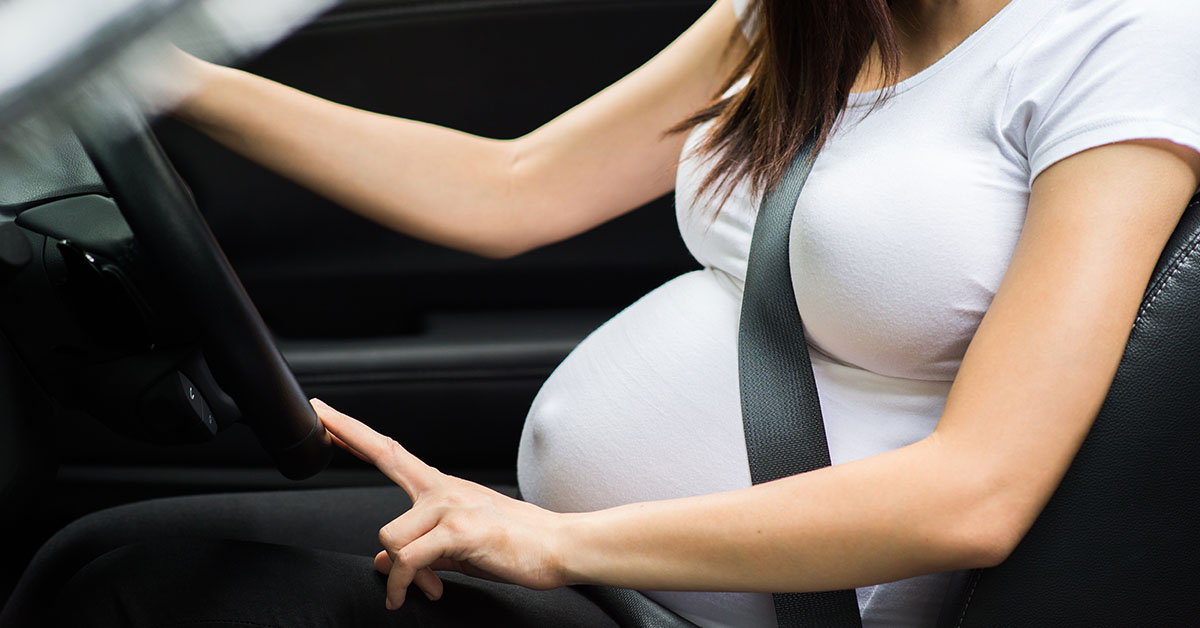 Pregnant woman in drivers seat of car