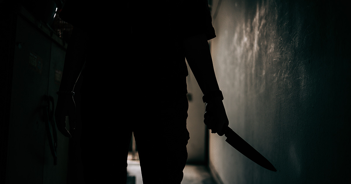 silhouette of person holding knife