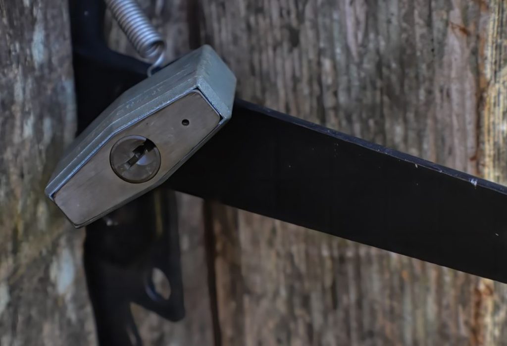 A padlock locking a wooden gate. 