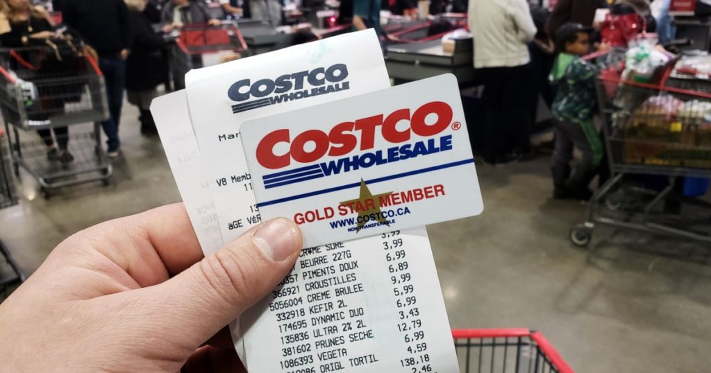 MONTREAL, CANADA - APRIL 6, 2019: A hand holding a receipt and Costco Membership card in Costco warehouse. Costco is an American corporation which operates a chain of membership