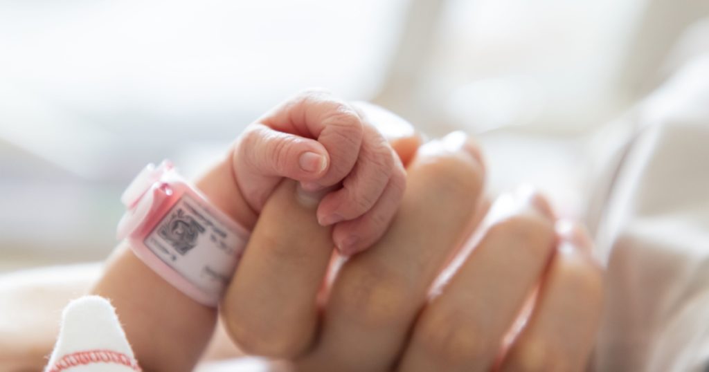 new born baby hand hold mum index finger. concept : Premature or preterm baby in hospital. relationship between mother and baby.