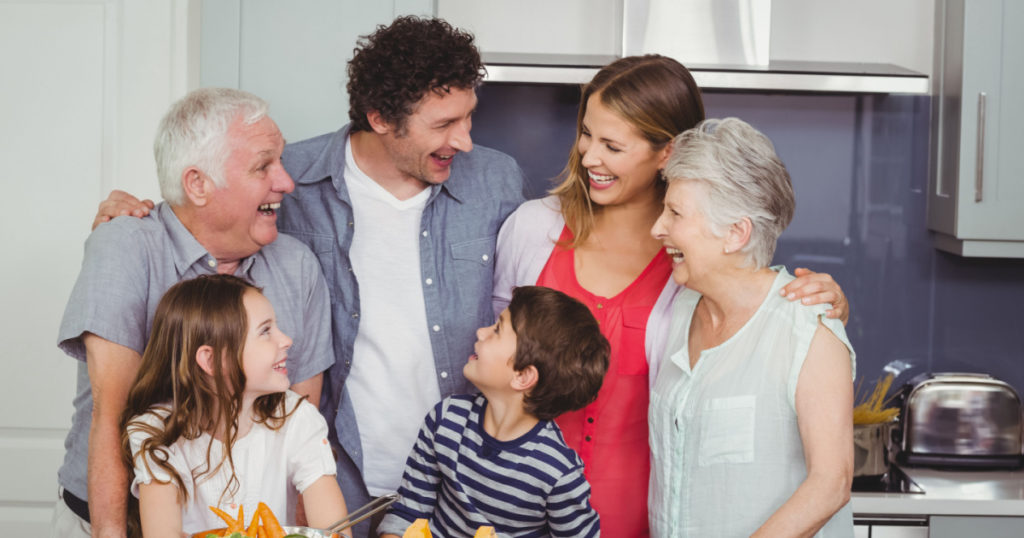 Smiling happy family standing in kitchen at home