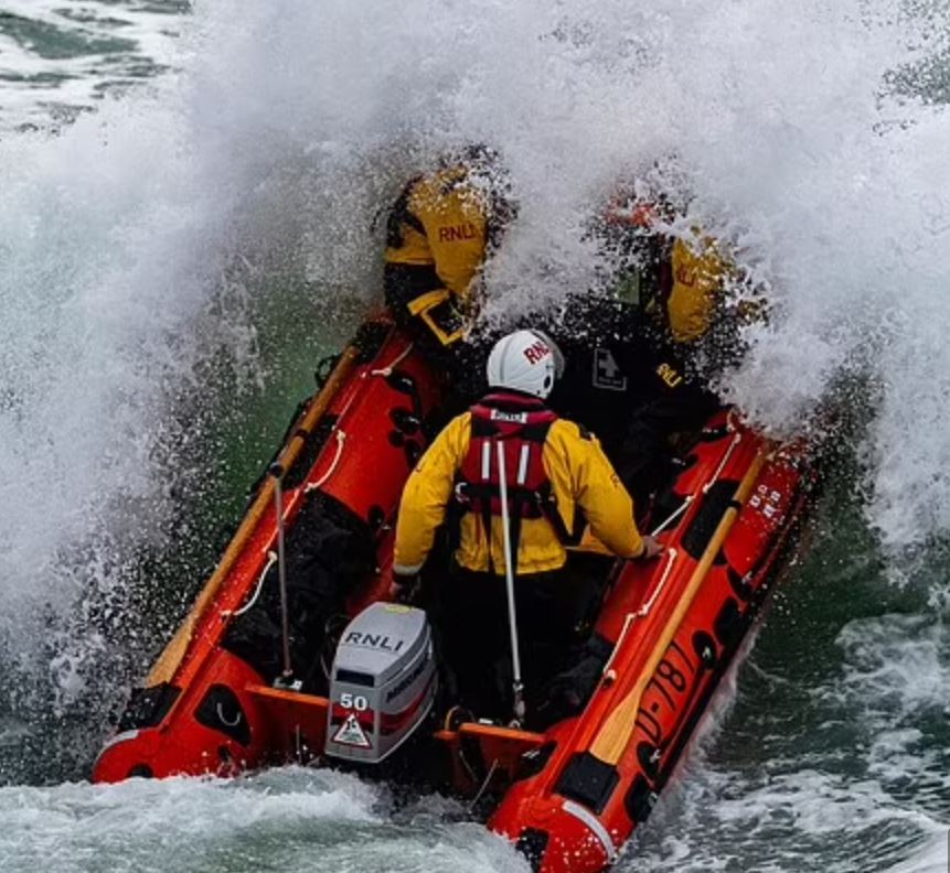 A rescue boat traveling through rough waters.