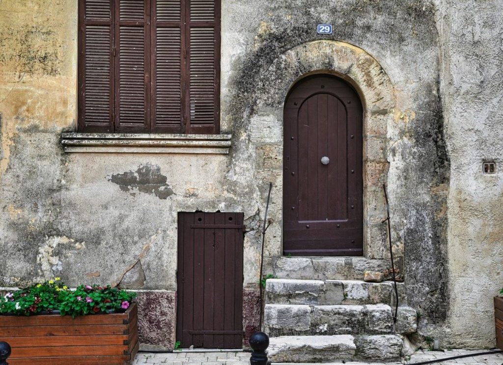 Old wooden doors and windows in a stone building. 