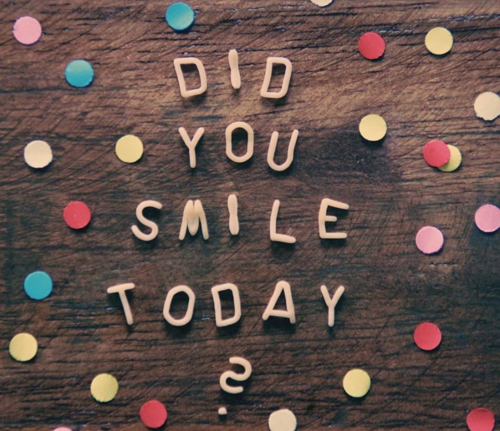 The words, "did you smile today?" against a brown background with colorful polka dots. 