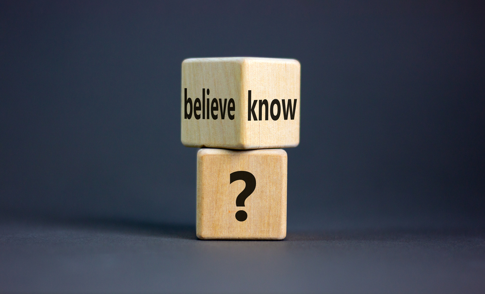 Conflict of knowing or believing. Wooden cubes with words 'believe' and 'know'. Beautiful grey background. Copy space. Concept.