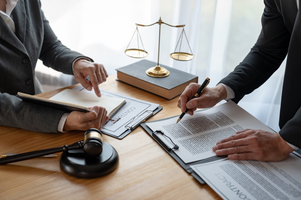 Lawyer, legal advisor, businessman brainstorming information on agreement details Business contracts in legal processing books for accuracy in contract documents. joint financial investment.