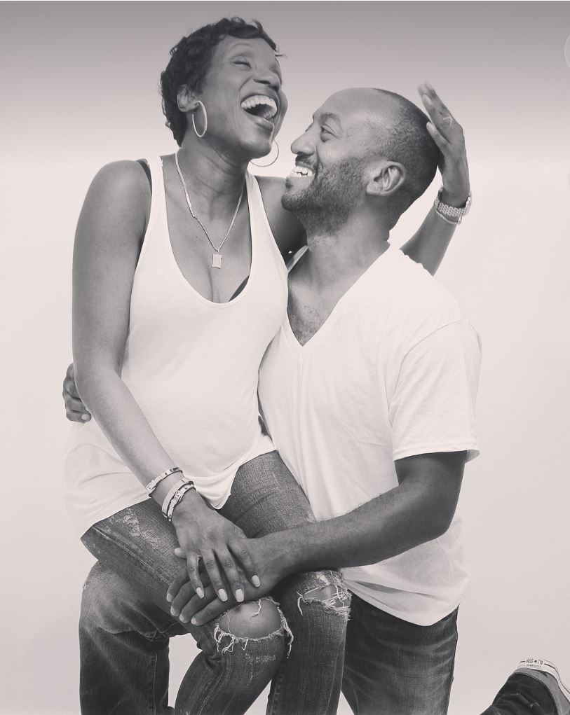 A woman sitting on a man's lap and laughing with him.