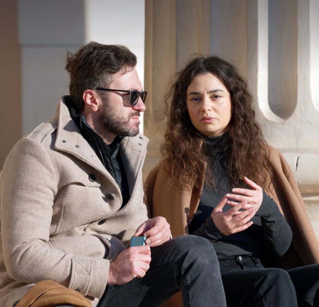 Couple sitting on steps and talking.