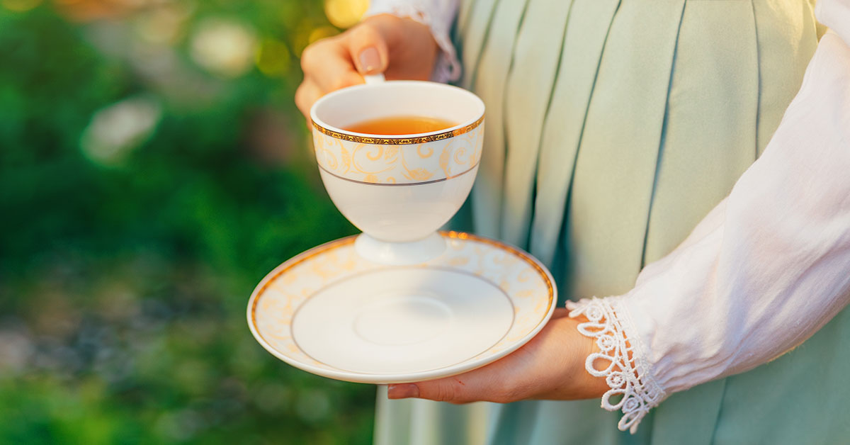 woman holding antique tea cup and saucer
