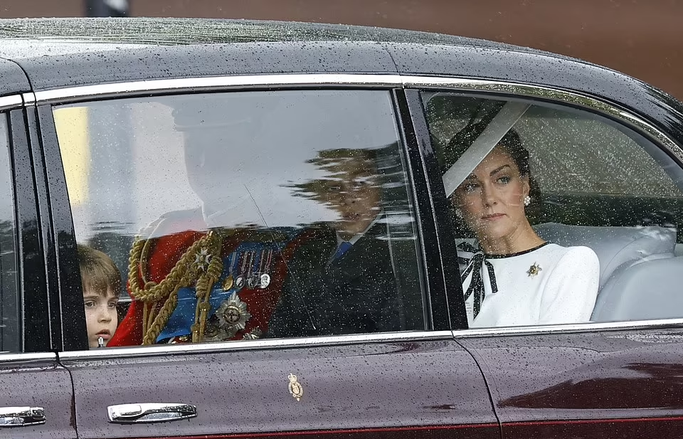 As they arrived at Buckingham Palace, she appeared pensive as she looked out of the window of their car while heavy rain fell.
