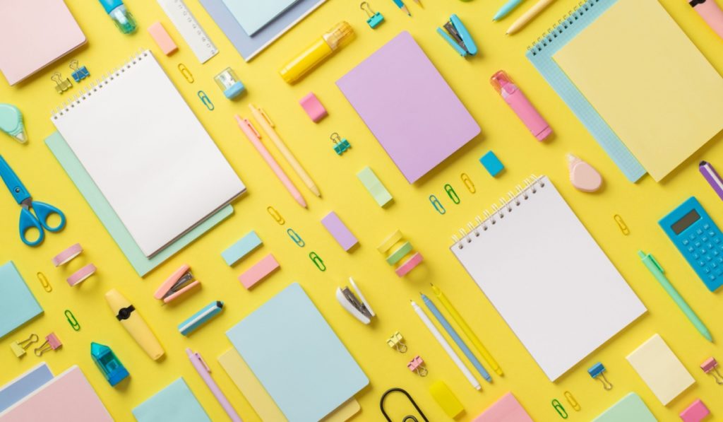 Top view photo of school supplies notebooks pencils correctors marker pens binder clips stapler calculator ruler adhesive tape scissors sharpener eraser sticky note paper on isolated yellow background