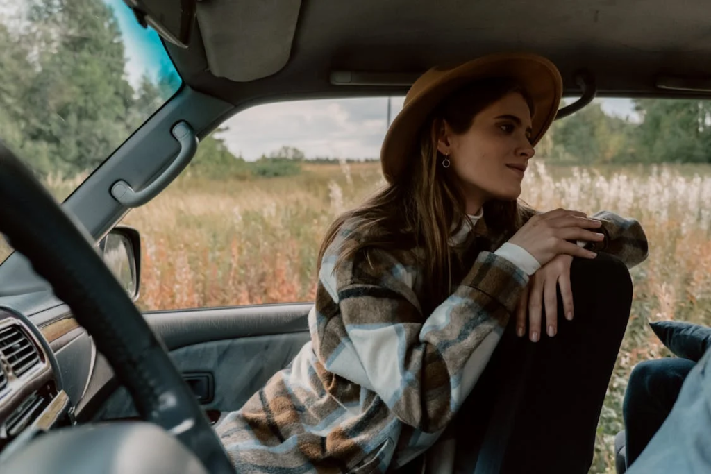 Woman in Brown and White Plaid Shirt Sitting in the Car
