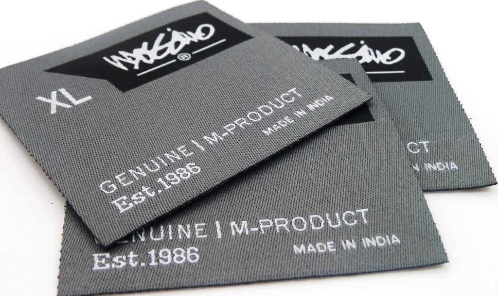 Clothing tags displaying the size, brand, and country of origin. 