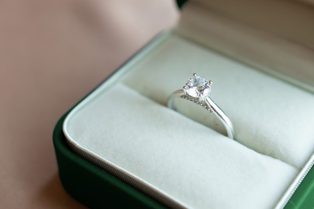 Diamond ring inside a small jewelry box.