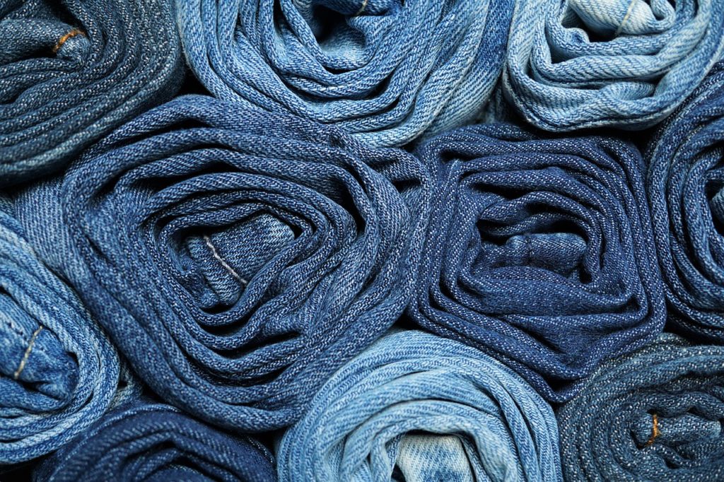 Pairs of rolled jeans stacked together. 