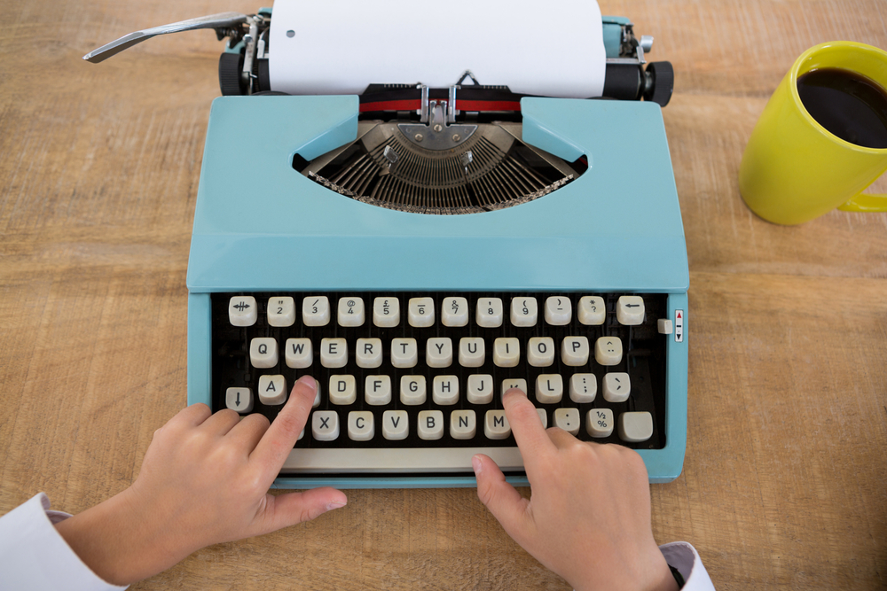 Close-up of hand of boy as business executive using typewriter