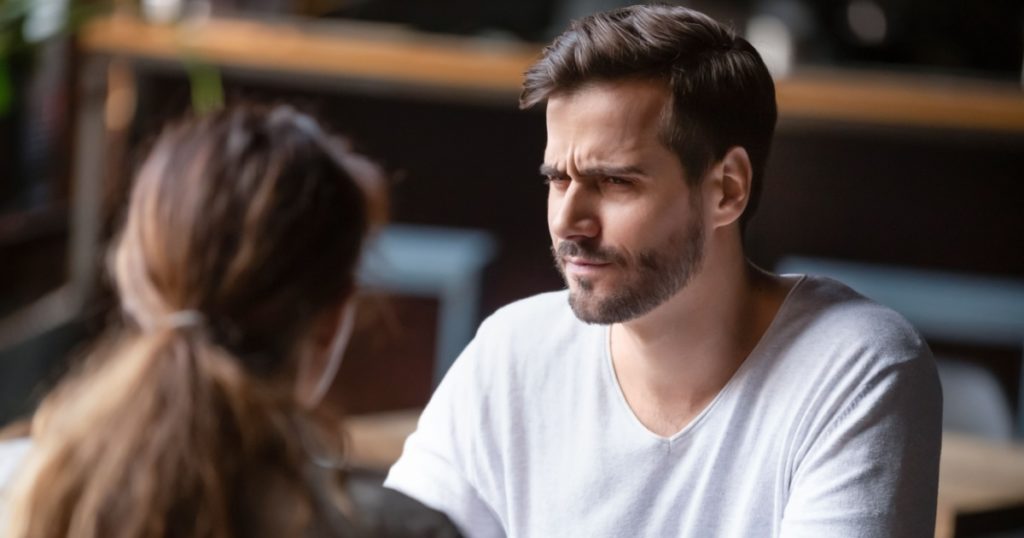 Doubting dissatisfied man looking at woman, bad first date concept, young couple sitting at table in cafe, talking, bad first impression, new acquaintance in public place, unpleasant conversation
