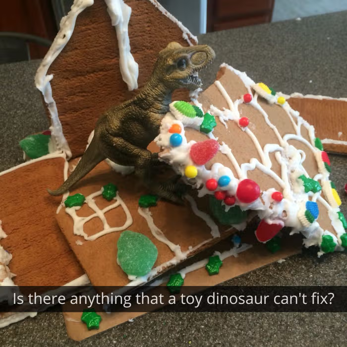 Dinosaur toy holding up a broken cake