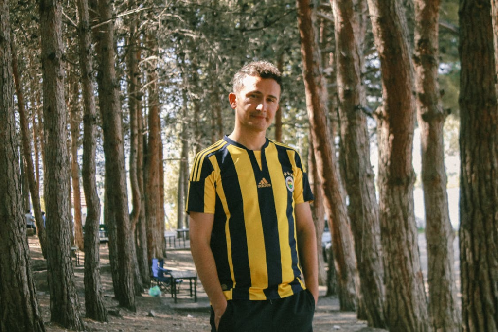 Man in Striped Yellow Black Football Shirt Posing in a Park