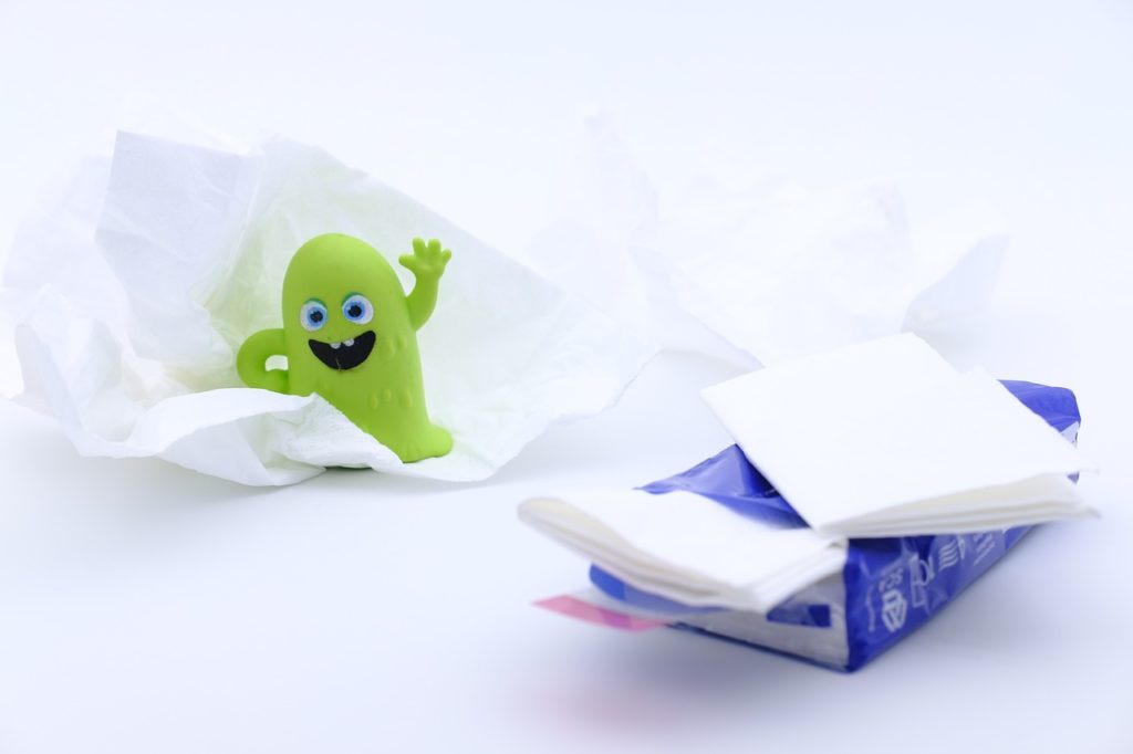 A pack of tissues and a green character with a white background.