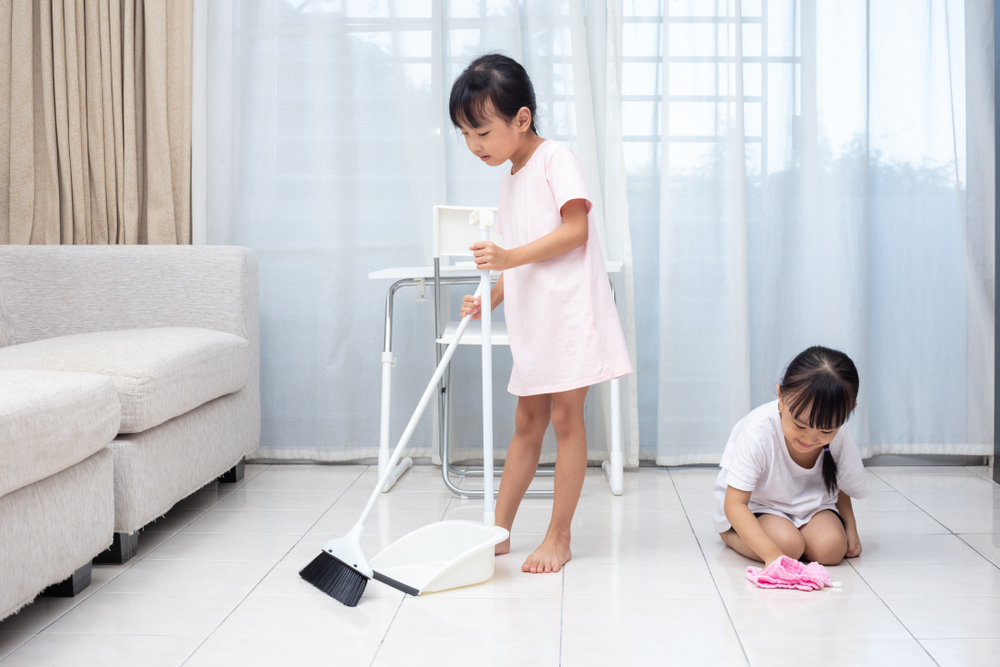 Asian Chinese little sisters helping doing cleaning at home