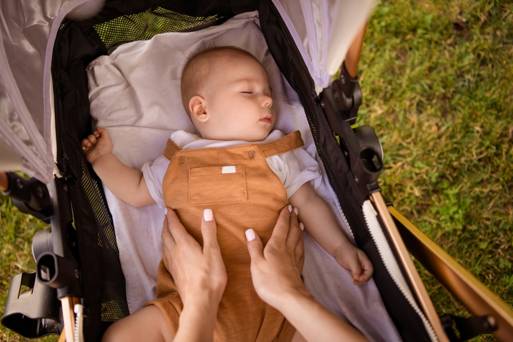 High angle first person view portrait of mother hands touch sleeping toddler pastime weekend walk outdoors