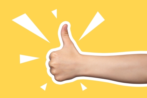 Child's hand shows thumbs up, class, like. Gesture isolated on yellow background. Modern design, positive. Art collage in magazine style