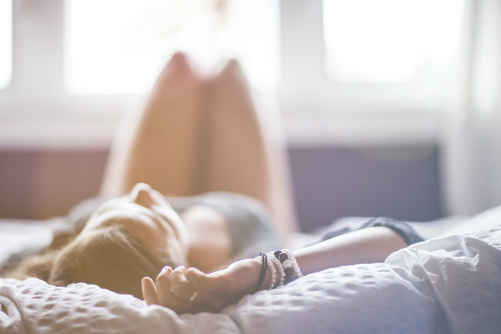 A blurred image of a woman sprawled out on a bed.