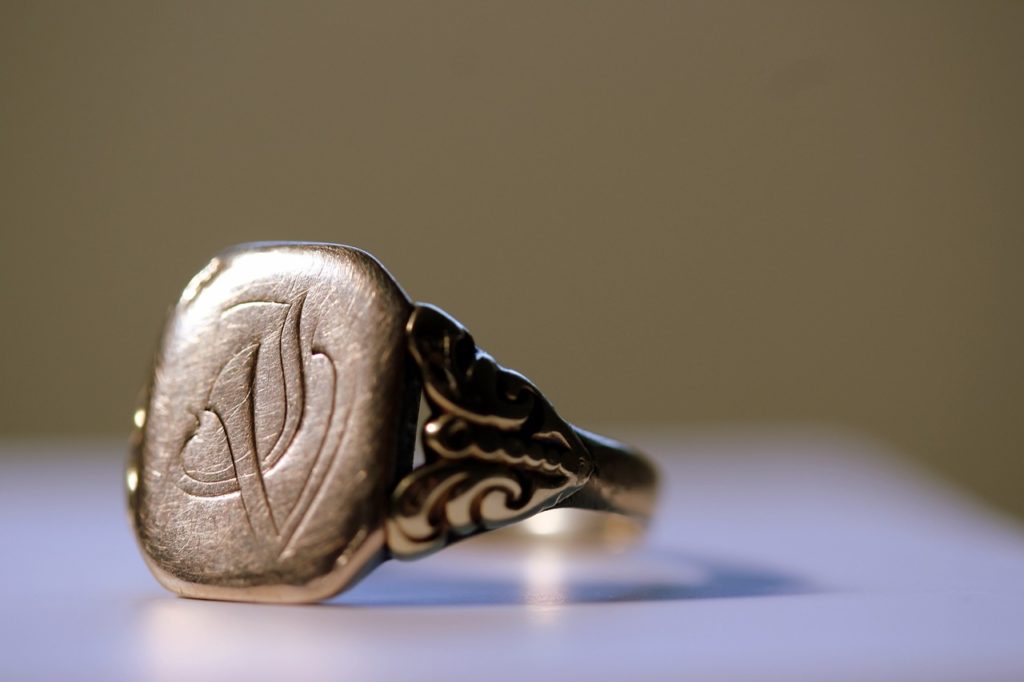 A signet ring. Blurred off white table and background