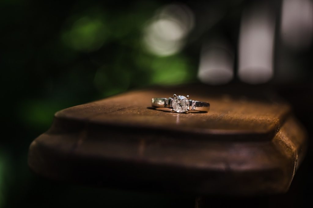A diamond ring on a wooden surface. Blurred background.