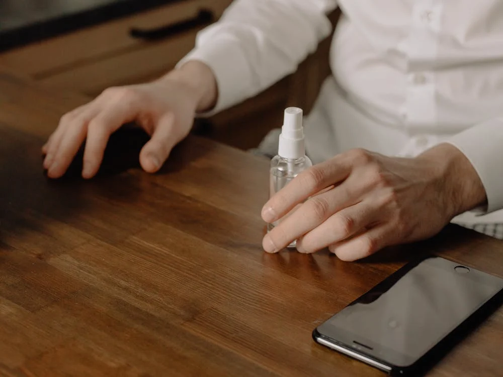 man holding spray bottle of sanitizer