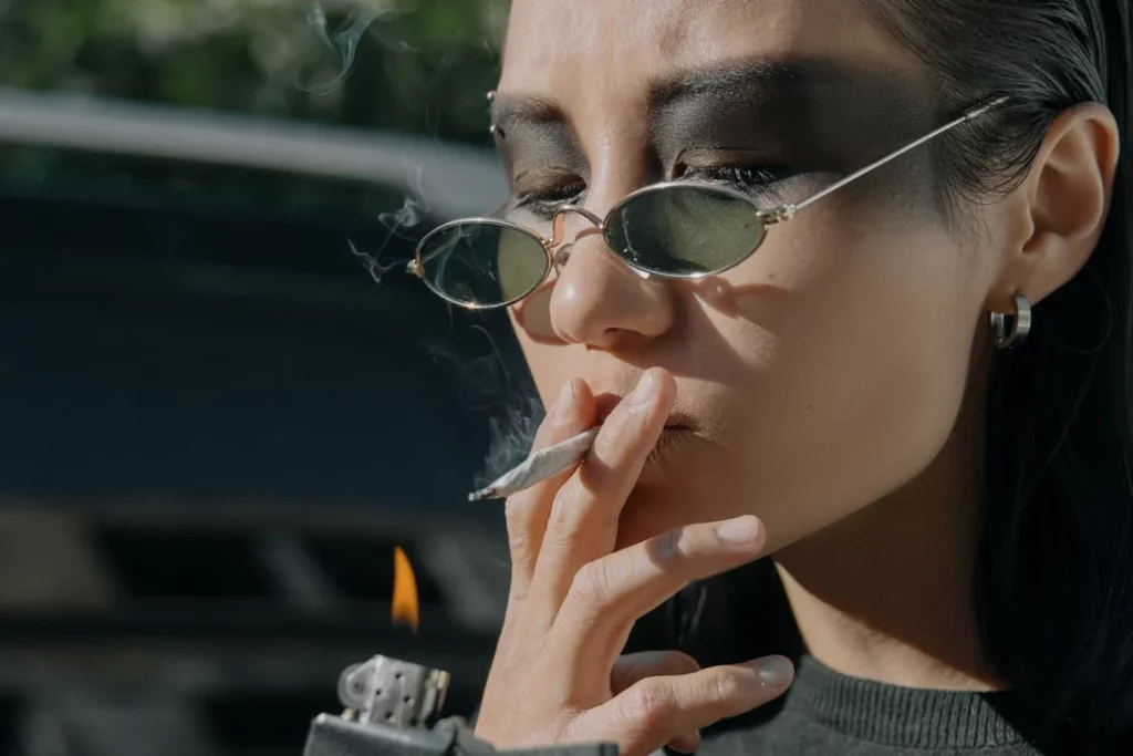 woman wearing sunglasses smoking a joint