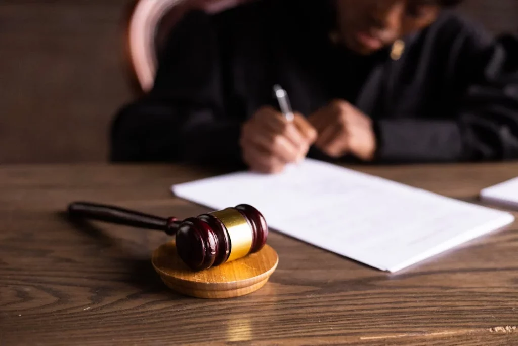 judge signing papers with gavel on desk