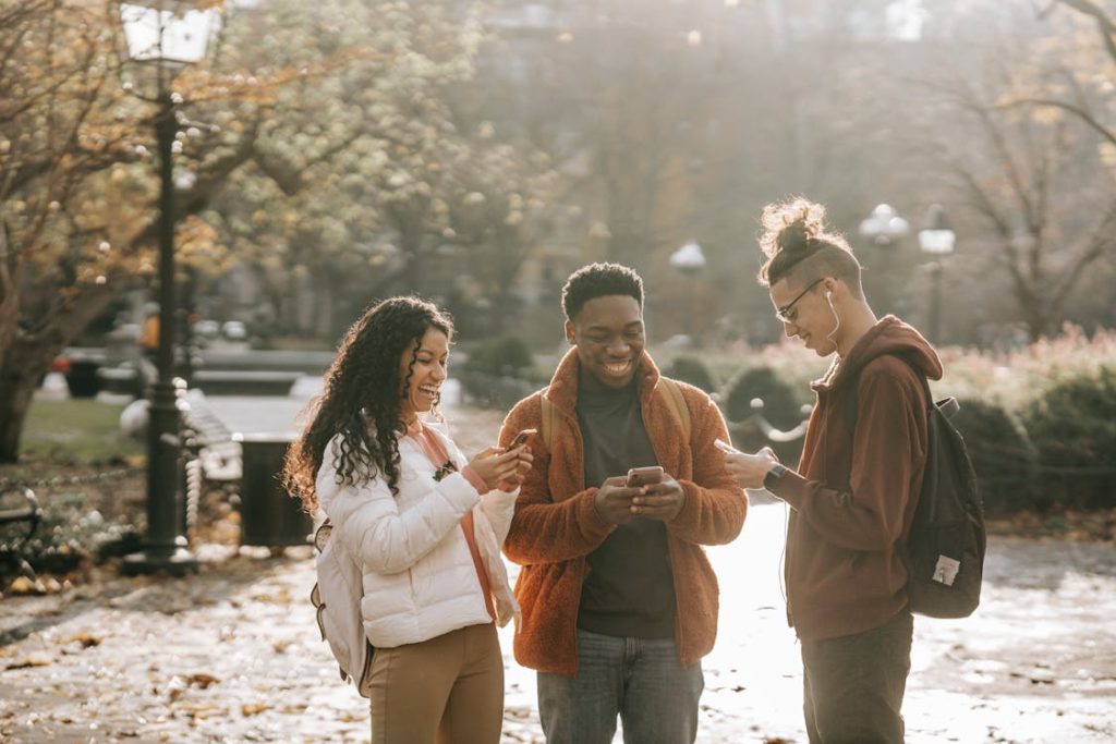3 people laughing while on their cellphones