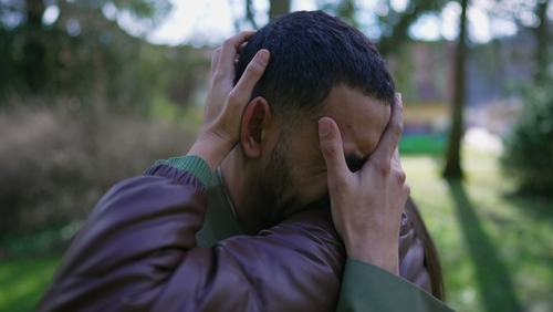Man suffering from grief being consoled by female friend standing outside. Empathic hug durring difficult times