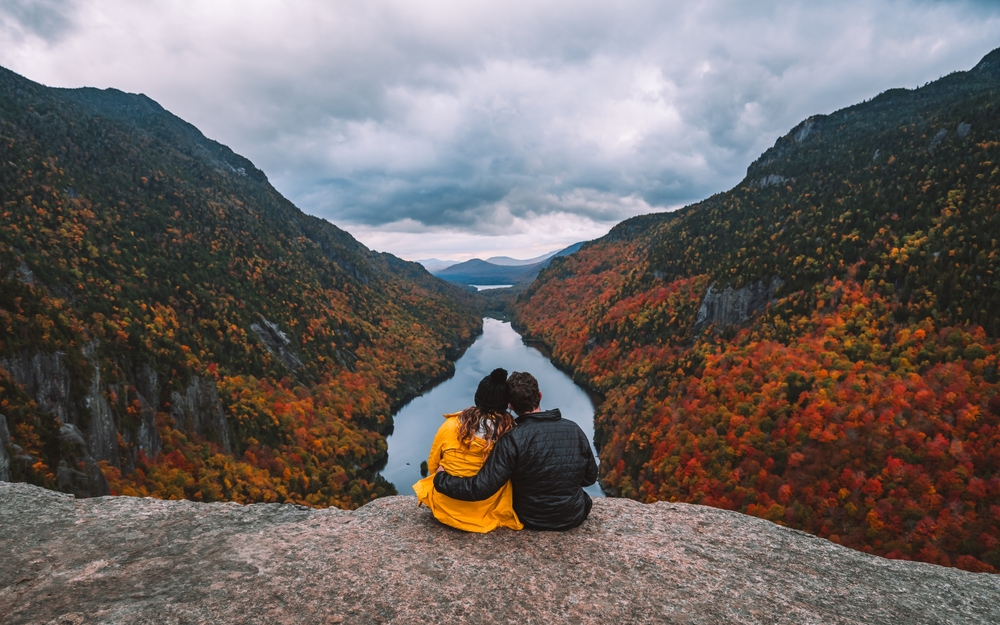 Hiking Adventure Couple Hold Each Other On Top of Mountain Autumn Fall Foliage Indian Head Adirondacks at Sunset. Relationship Love Travel Landscape