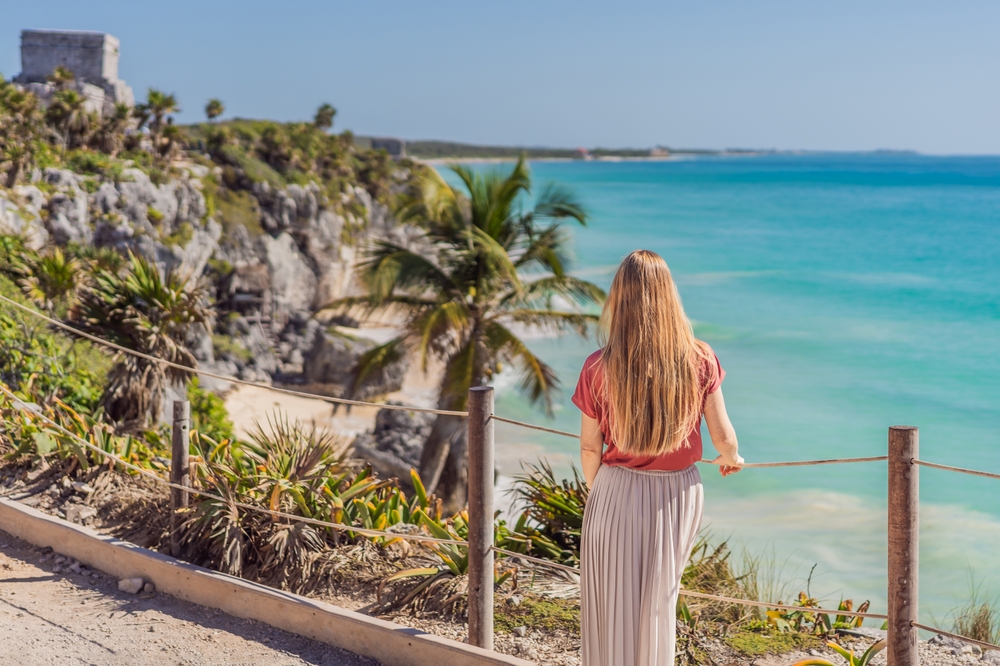 Woman tourist enjoying the view Pre-Columbian Mayan walled city of Tulum, Quintana Roo, Mexico, North America, Tulum, Mexico. El Castillo - castle the Mayan city of Tulum main temple